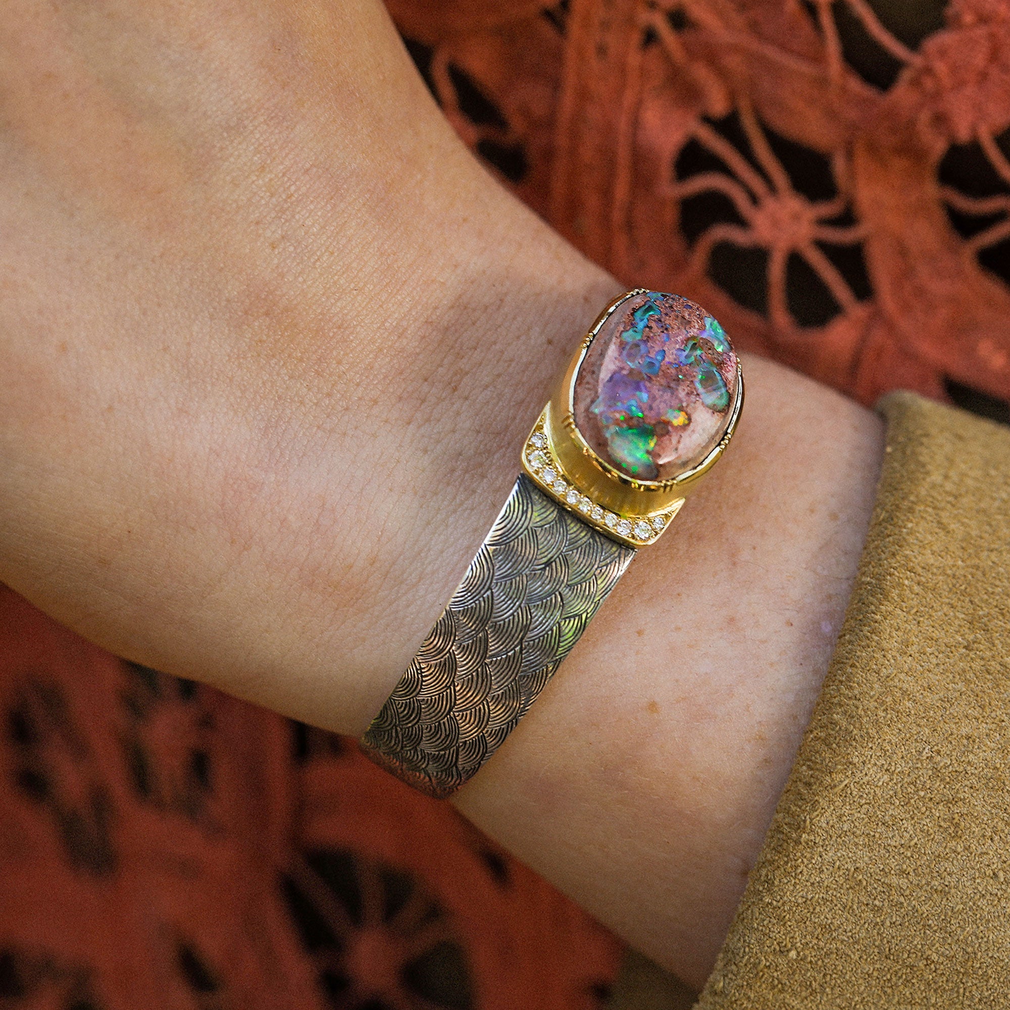 Model wearing one of a kind 18k gold and silver hand engraved cuff bracelet featuring a central Matrix Fire Opal with diamond pave detail from Los Angeles jewelry designer Brooke Gregson