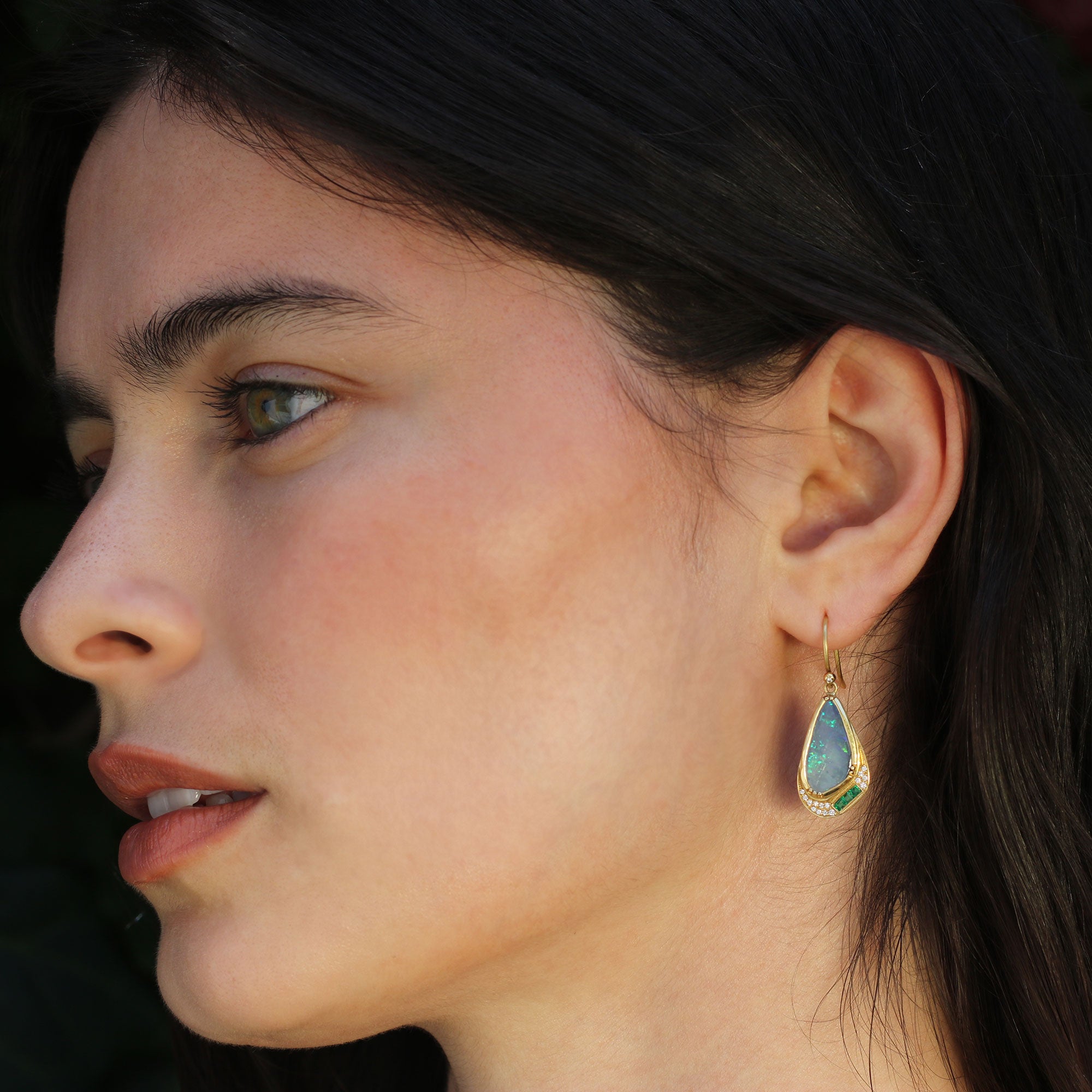 Model wearing one of a kind 18k gold boulder opal earrings with emerald and diamond from Los Angeles jewelry designer Brooke Gregson.
