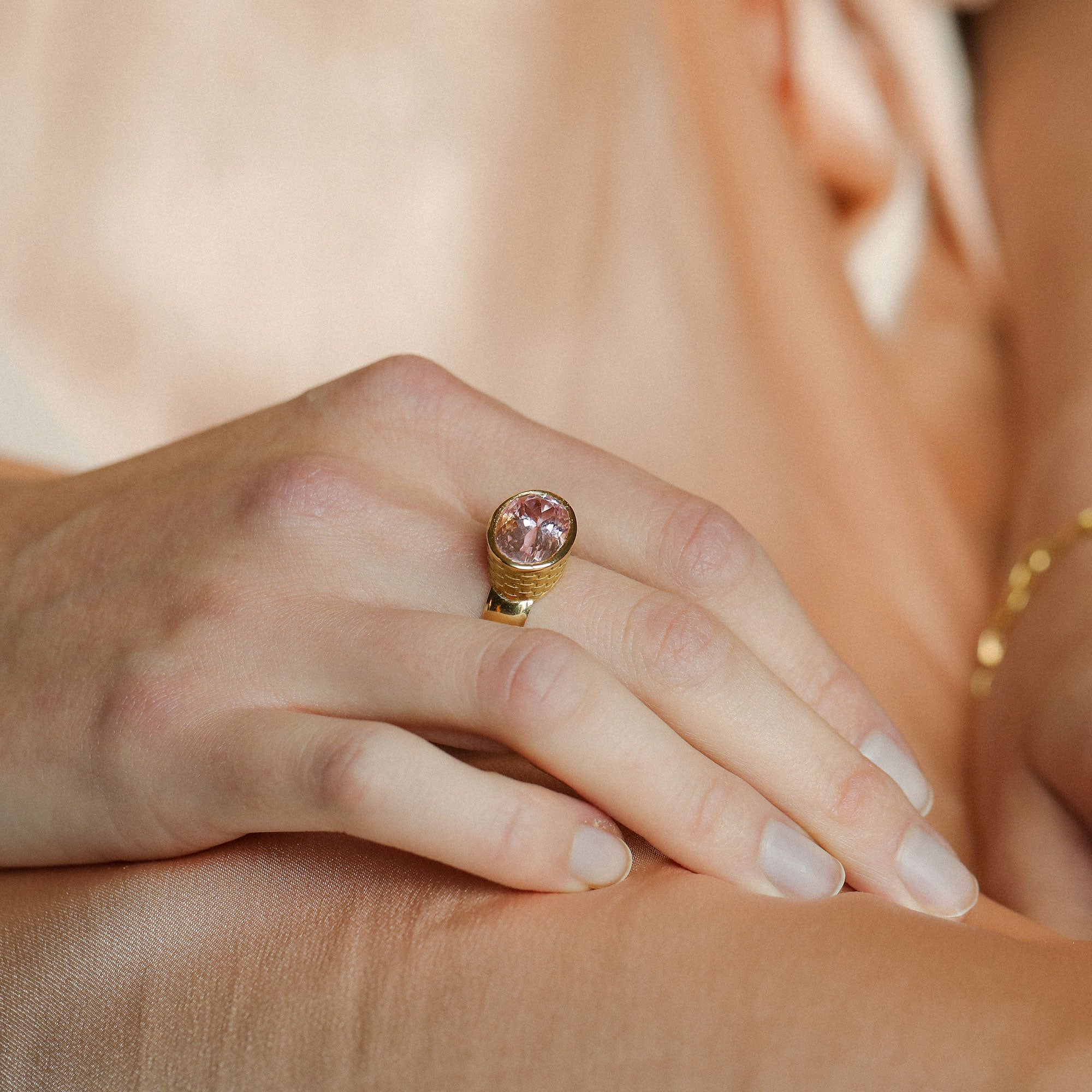 Model wearing one of a kind 18k gold kunzite ring with basket weave engraved setting and bushed gold band from Los Angeles jewelry designer Brooke Gregson
