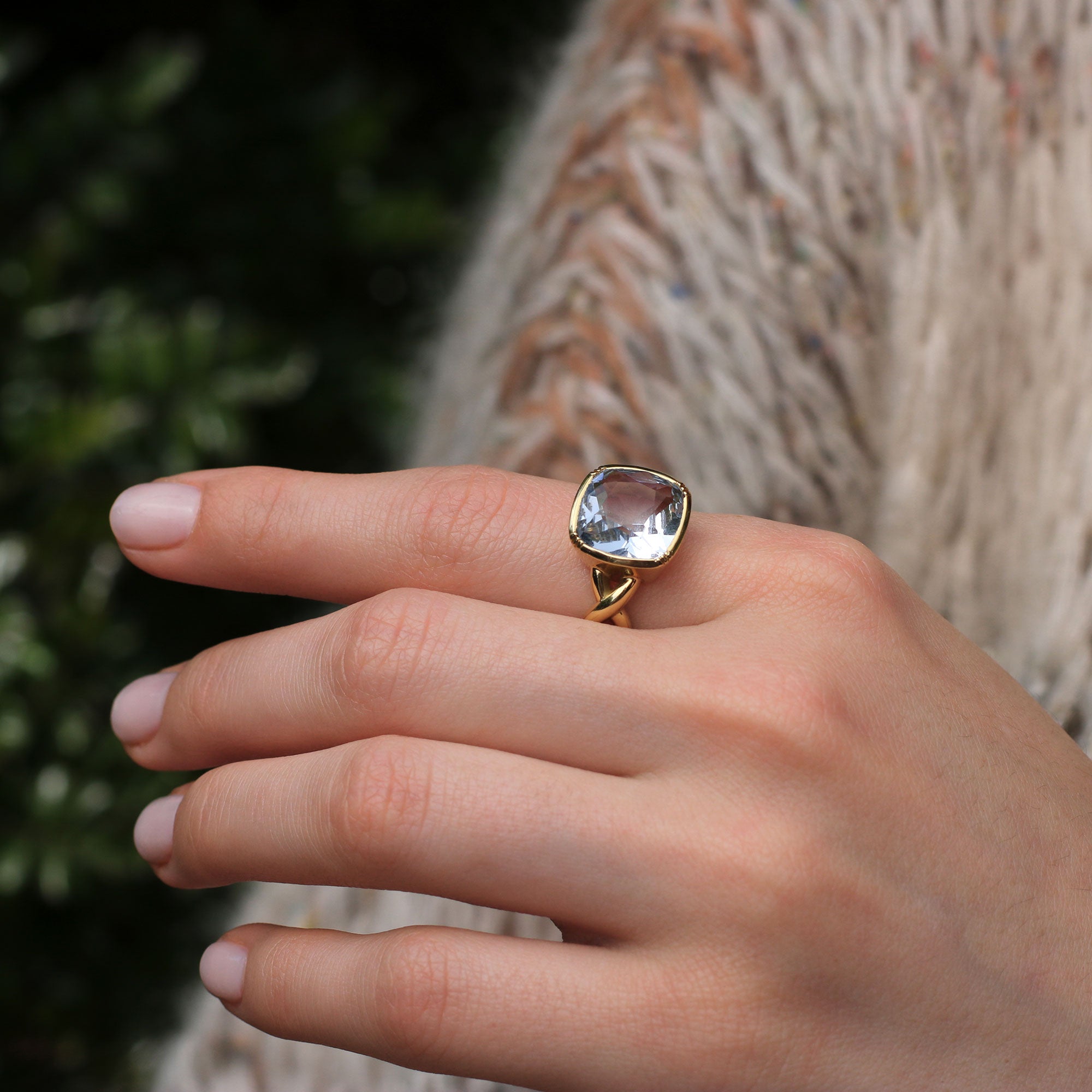 Model hand with One of a kind 18k gold Aquamarine ring with twisted gold band from Los Angeles fine jewelry designer Brooke Gregson handmade in London.