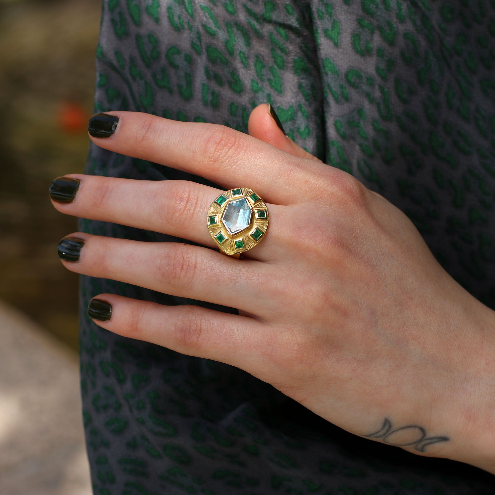 Hand showing 18k gold Utopia Engraved Aquamarine Emerald Ring by Los Angeles fine jewelry designer Brooke Gregson handmade in London