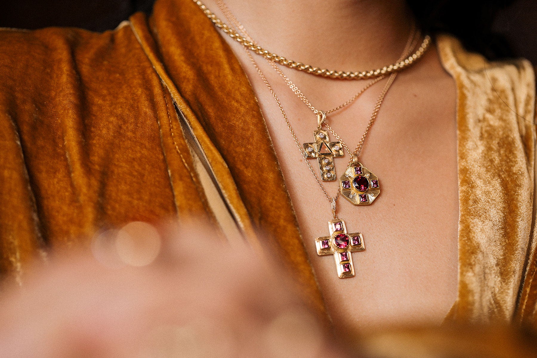 Close-up of a person wearing gold necklaces with cross pendants.
