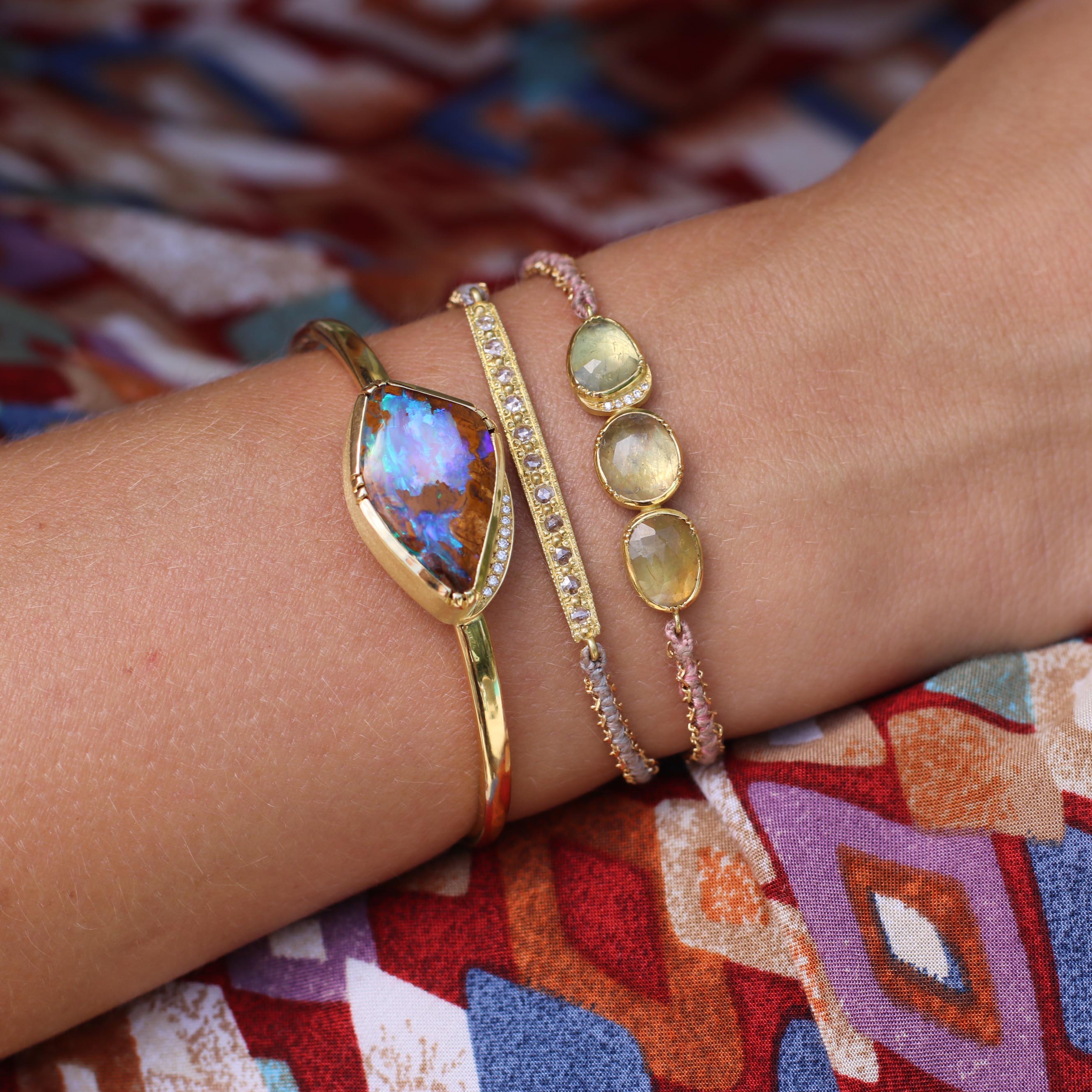 Model wearing multiple bracelets including one of a kind Sapphire and Diamond bracelet hand woven with silk and 18k gold chain fromLos Angeles jewelry designer Brooke Gregson