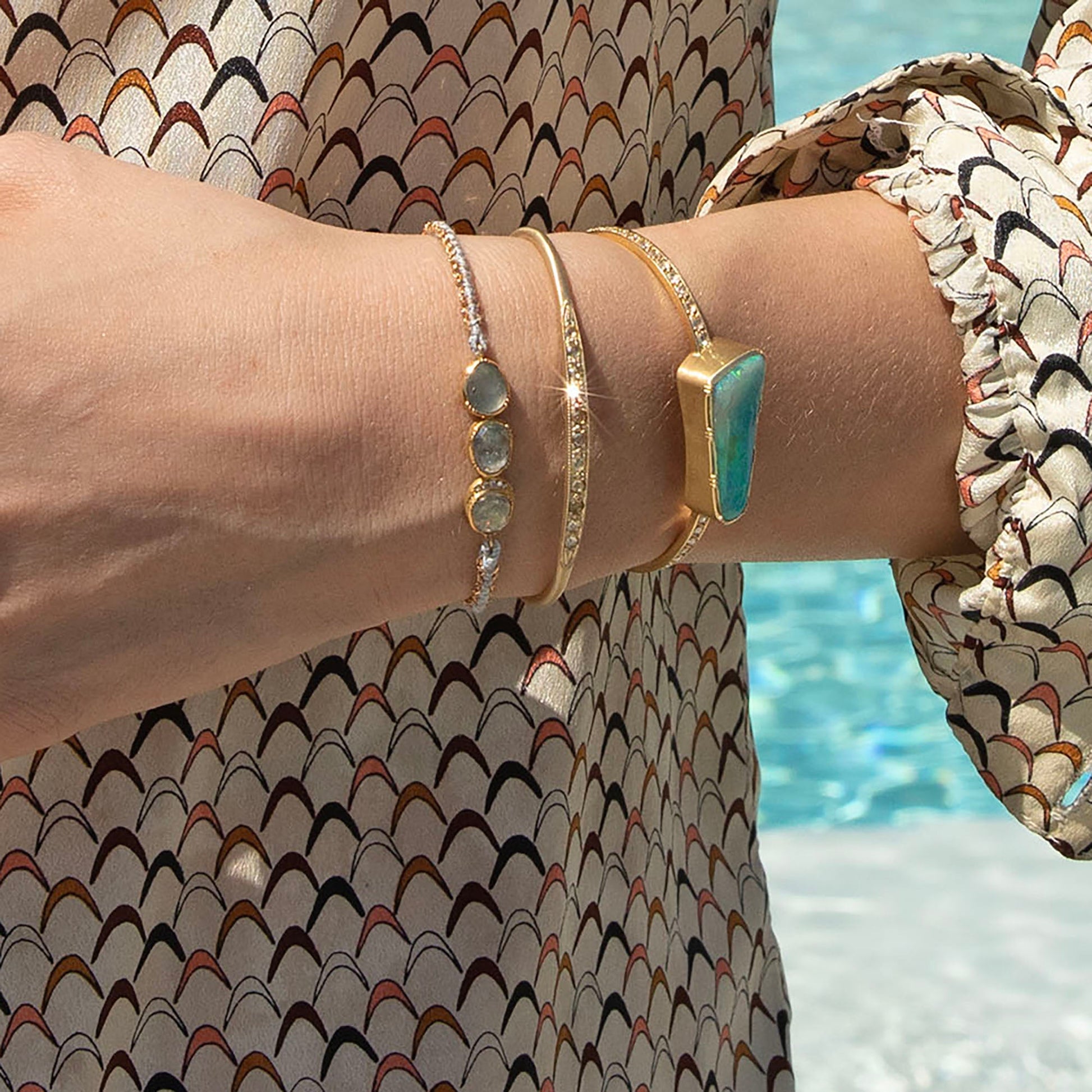Model wearing multiple bracelets including  14k gold mixed champagne, yellow and cognac diamond cuff from Brooke Gregson handmade in Los Angeles.