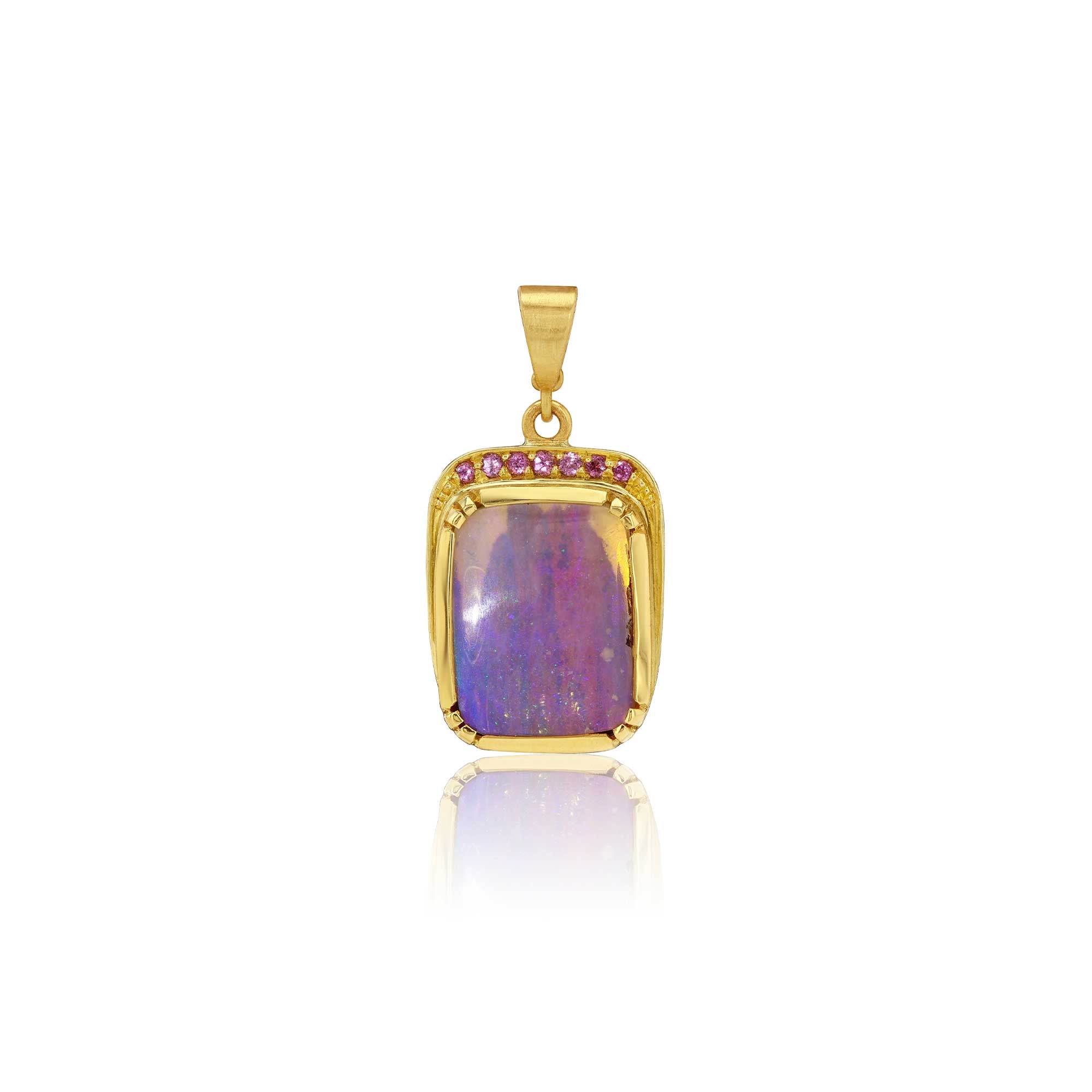 A gold pendant featuring a rectangular cabochon fossilised wood opal with vibrant purple, blue, and pink flashes, bordered by small garnet gemstones, set against a plain white background with a soft reflection.