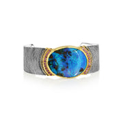 Sterling Silver and 18k gold hand engraved cuff with blue opal gemstone and pink spinel and sapphire stones on a white background