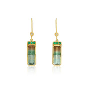 A pair of gold drop earrings featuring rectangular green and brown gradient tricolor tourmalines, accented with three small green emerald stones on each earring, set against a plain white background.