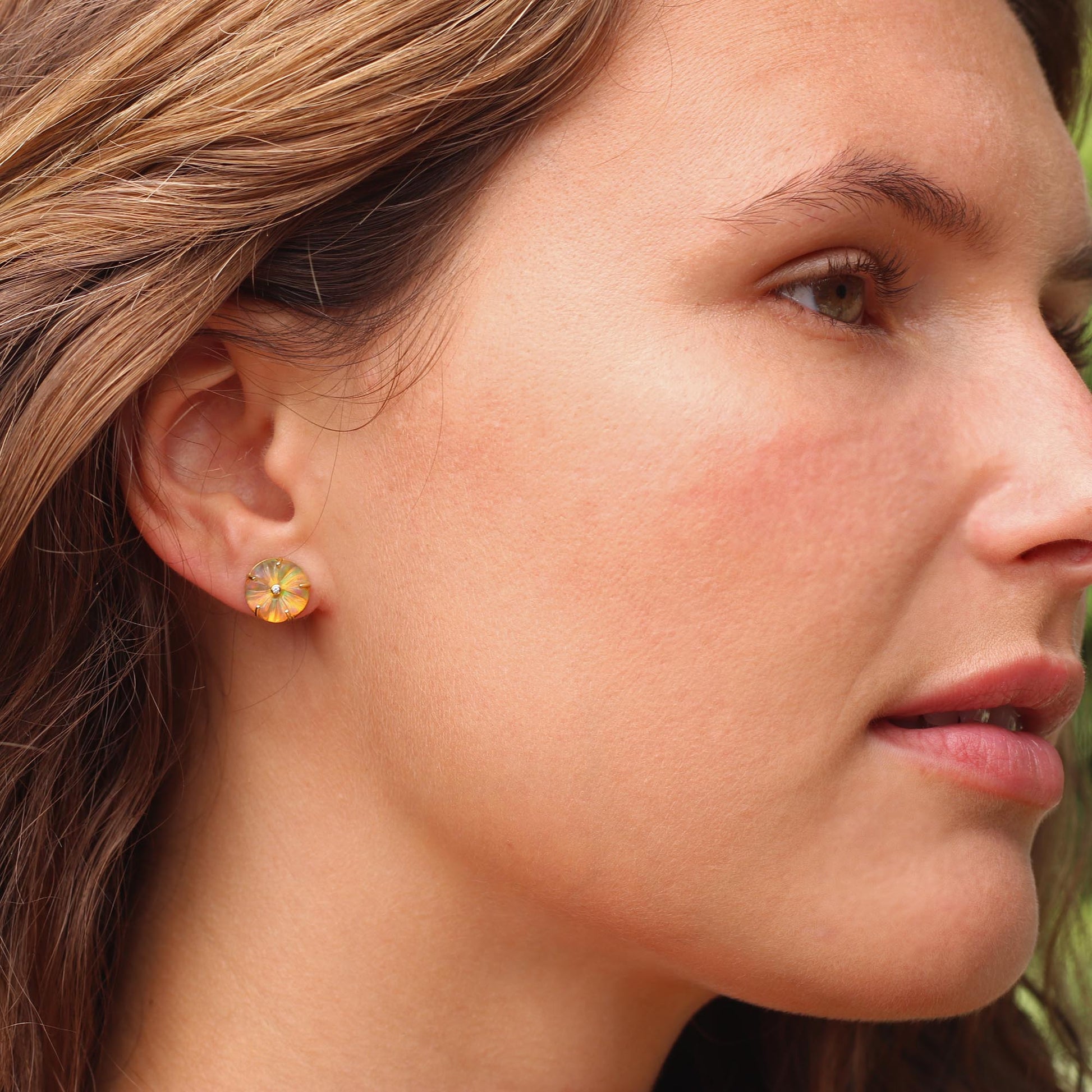 Model wearing Hand carved 18k gold fine jewelry Opal flower blossom earrings with claw setting and diamond centre. Fine jewelry hand made in London from Los Angeles designer Brooke Gregson.