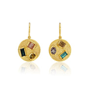 Gold earrings with embedded sapphire gemstones on a white background