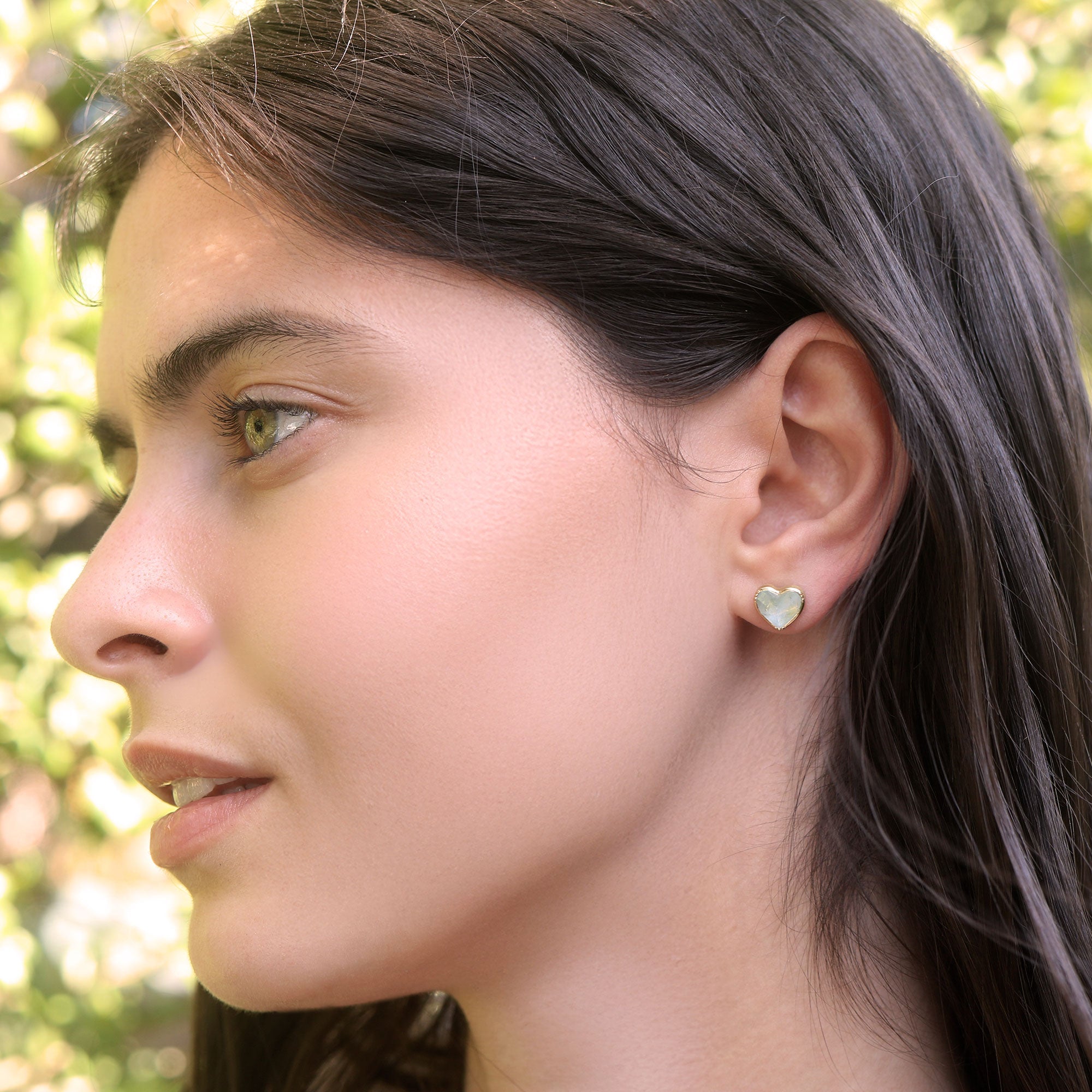 Model wearing one of a kind Aquamarine heart stud earrings from fine jewelry designer Brooke Gregson handmade in London
