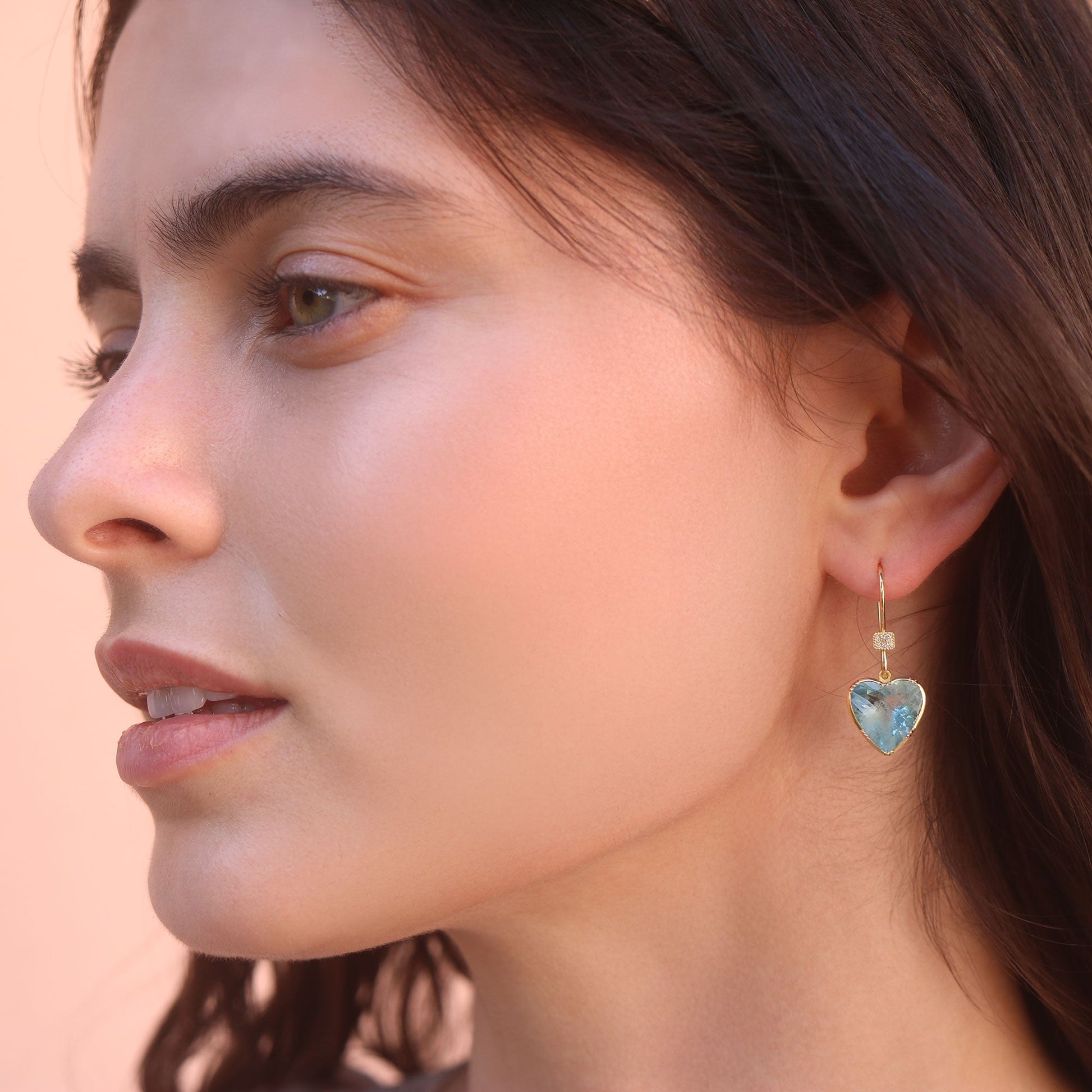 Model wearing one of a kind Aquamarine heart earrings with diamond pave ear loop from fine jewelry designer Brooke Gregson handmade in London