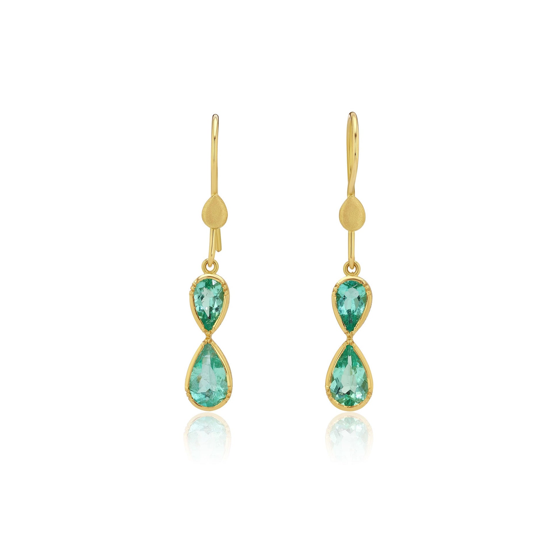 Gold earrings with emerald gemstones in an infinity shape on a white background
