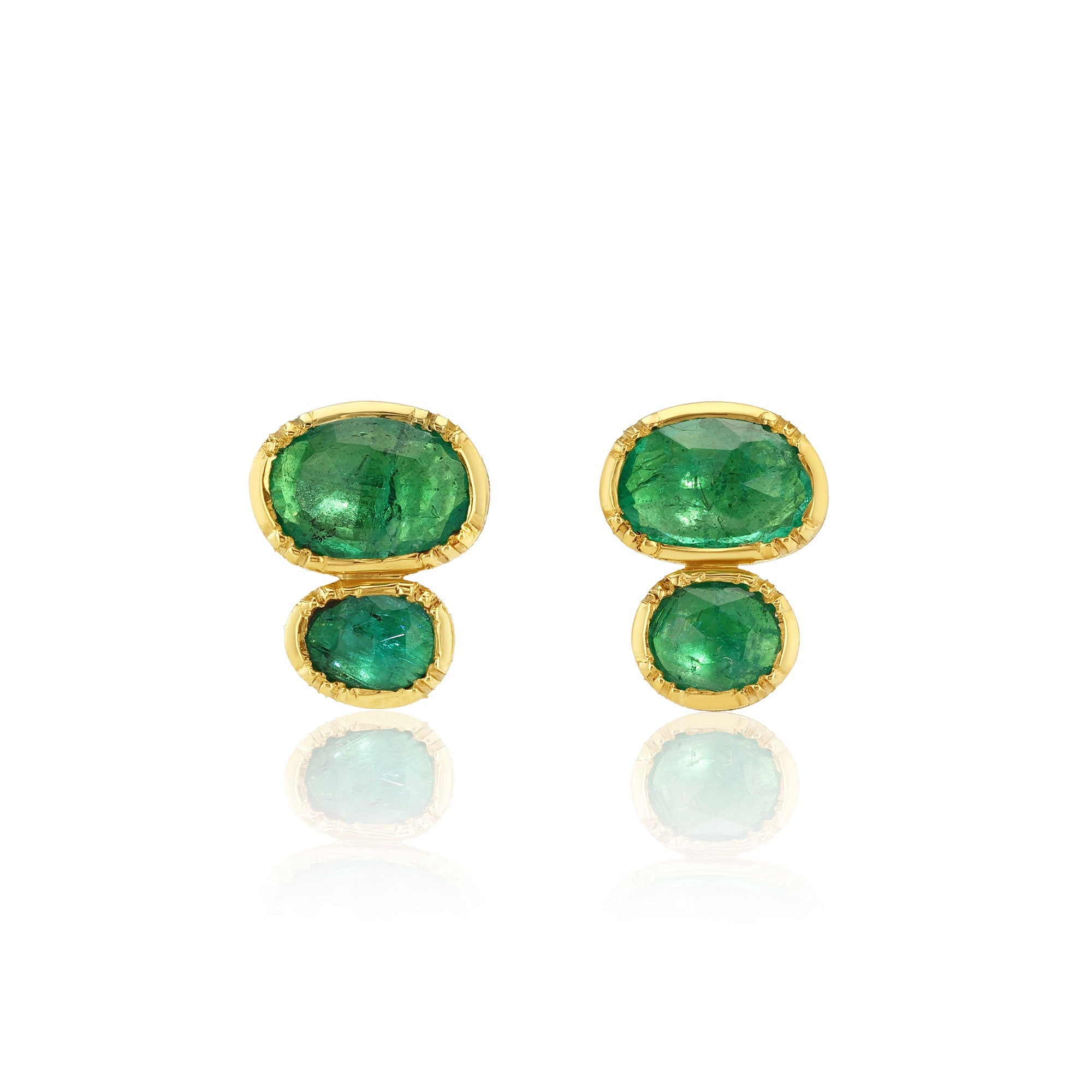 Gold earrings with green emerald gemstones on a white background