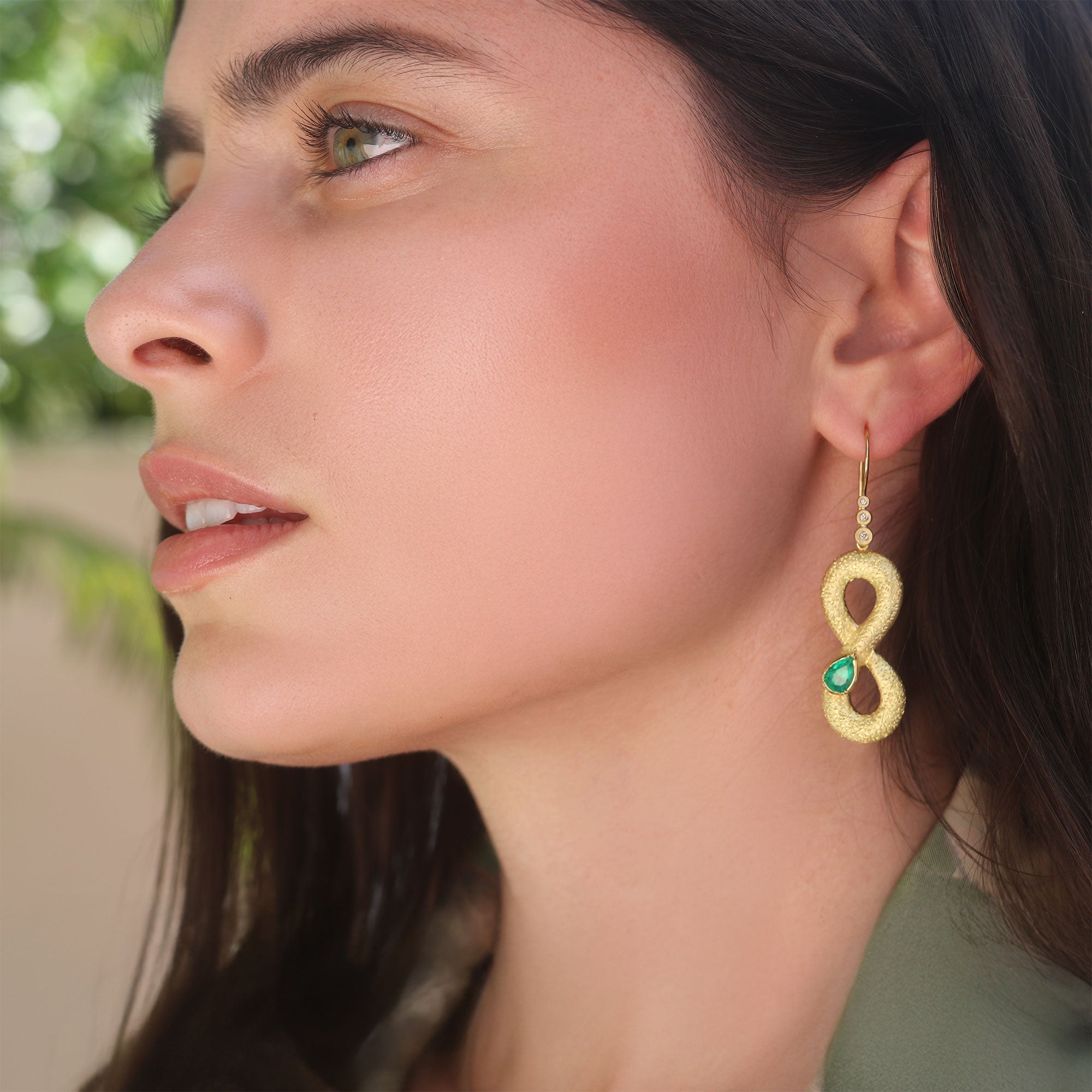 Model wearing one of a kind 18k gold Emerald snake earrings with Diamond ear loop from Los Angeles designer Brooke Gregson fine jewelry handmade in London