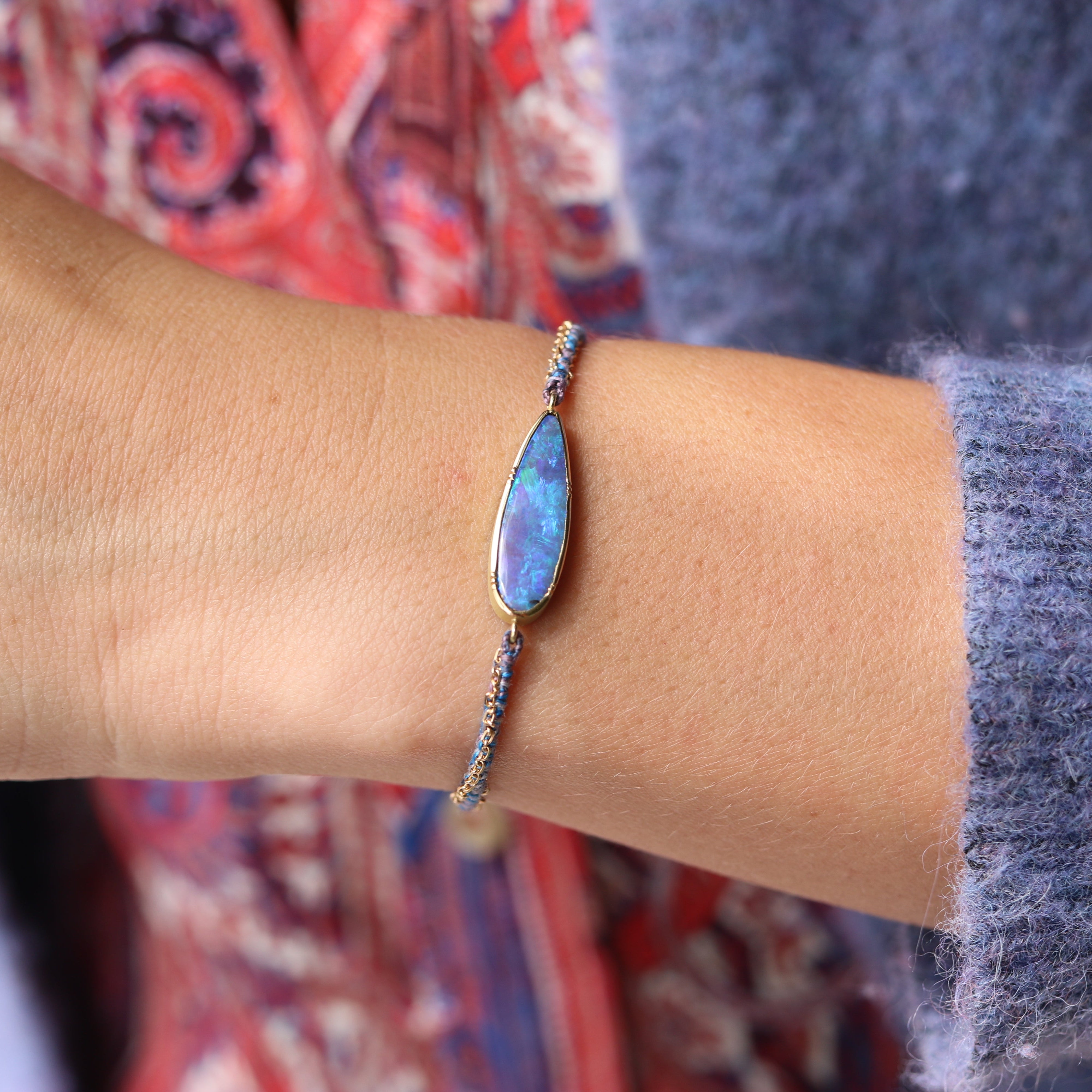 Model wearing one of a kind Boulder Opal bracelet with hand woven silk and 18k gold chain bracelet from Los Angeles jewelry designer Brooke Gregson.