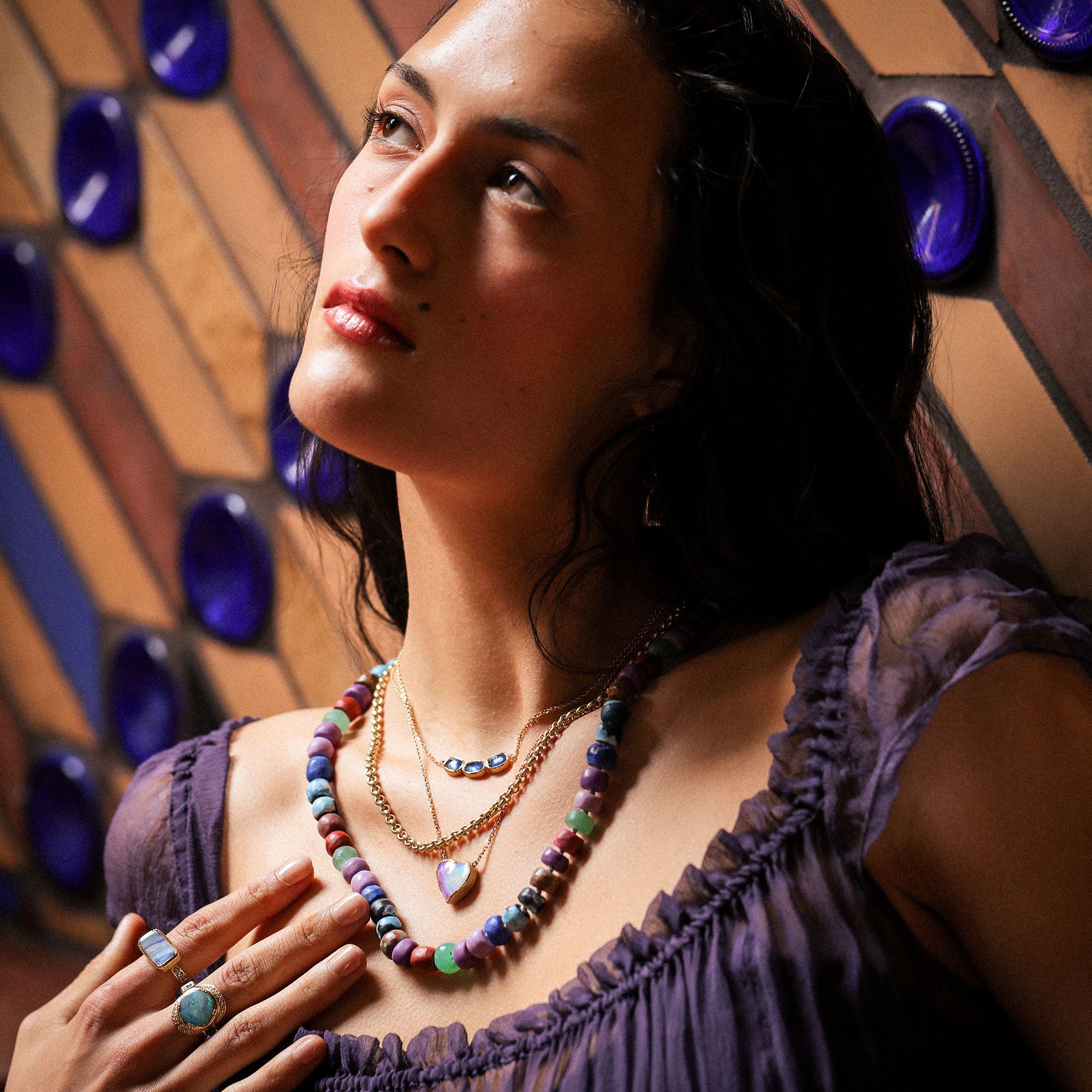 girl wearing layers of necklaces designed by brooke gregson