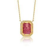 Gold necklace with a red ruby buddah gemstone pendant on a white background