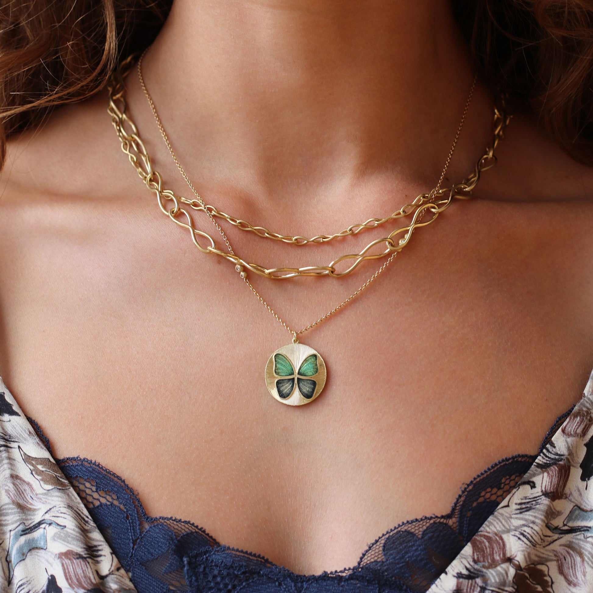 Model wearing Handmade Enamel 18k gold green and blue butterfly enamel necklace with hand engraving Fine jewelry hand made in London. 