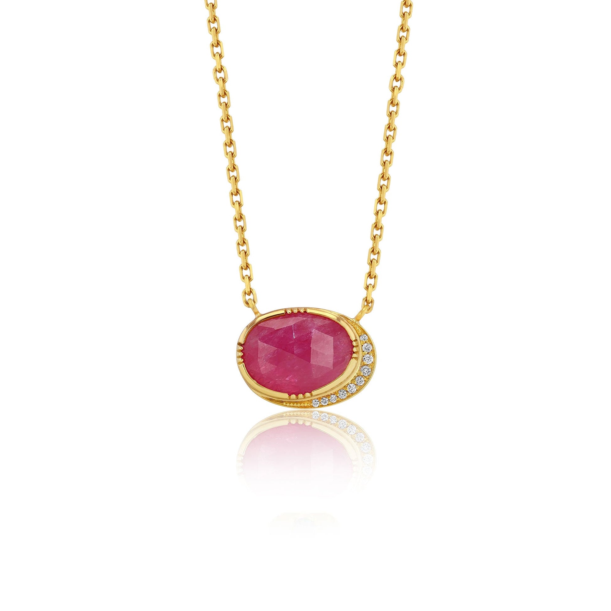 Gold necklace with a red ruby gemstone pendant on a white background