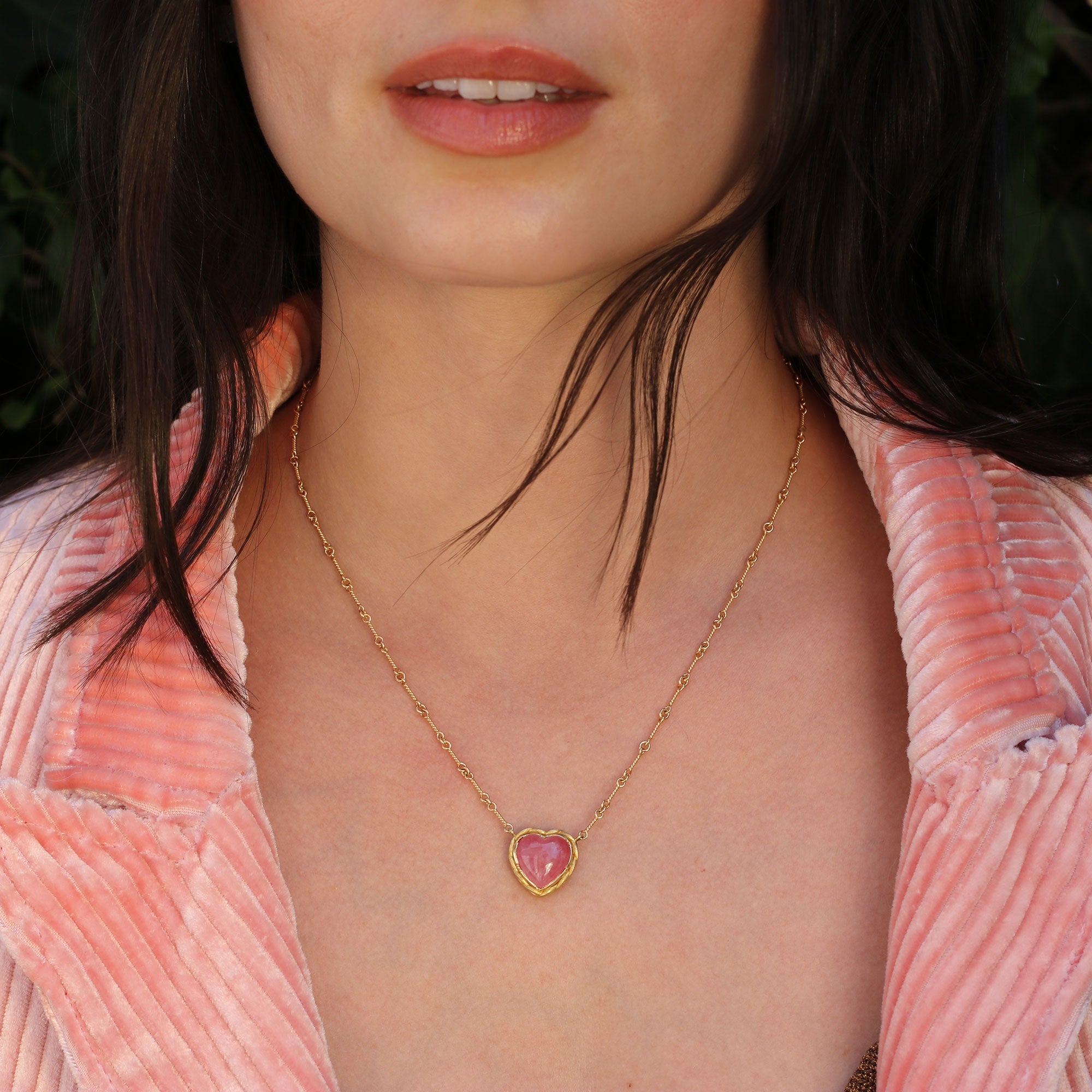 Model wearing 18k gold rhodochrosite heart necklace with twist rope chain from Los Angeles designer Brooke Gregson handmade in London