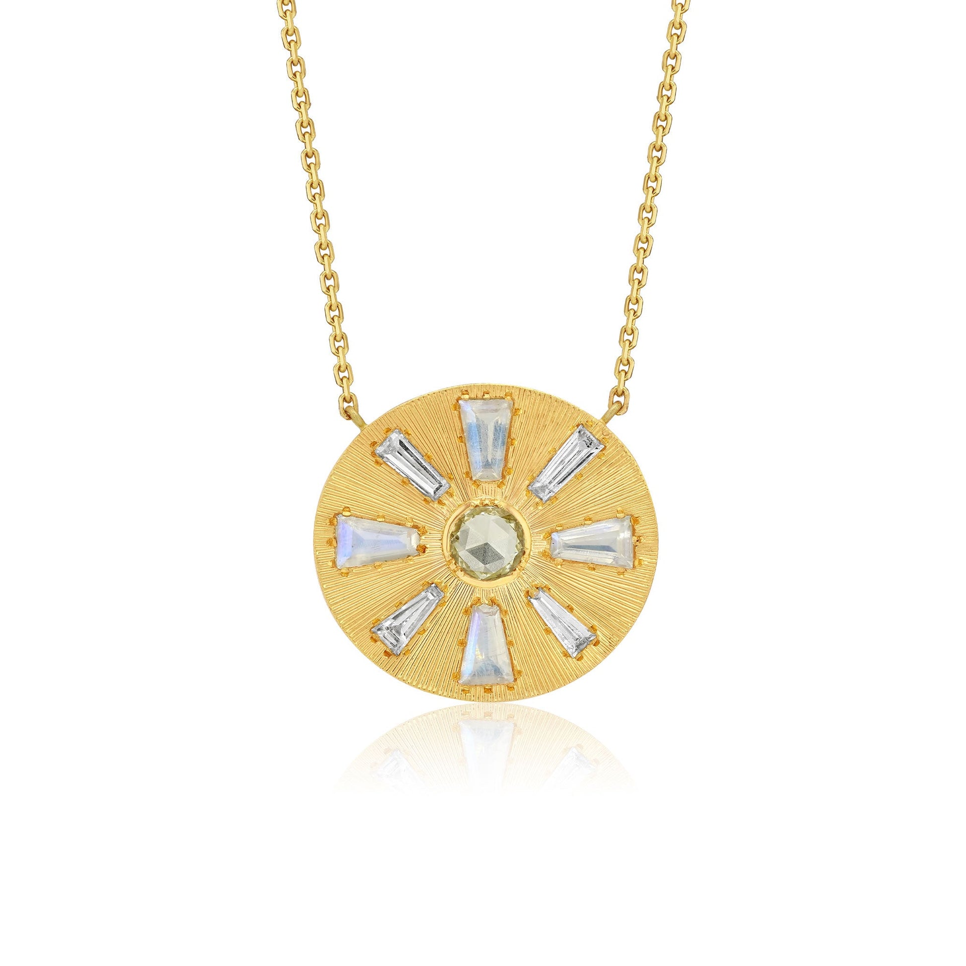 A gold circular pendant necklace featuring a sunburst design with clear baguette-cut diamond stones and a central round pale green diamond gemstone, suspended from a delicate gold chain against a white background.
