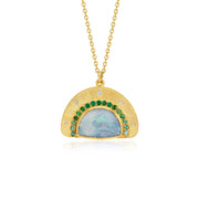 A gold hand engraved pendant necklace featuring a semi-circular gold frame with a central iridescent blue opal and a border of green emerald and tourmaline stones and small diamond stones, suspended from a gold chain on a white background.