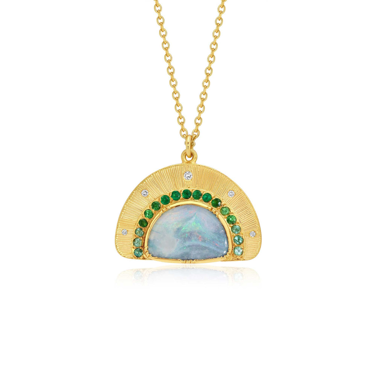 A gold hand engraved pendant necklace featuring a semi-circular gold frame with a central iridescent blue opal and a border of green emerald and tourmaline stones and small diamond stones, suspended from a gold chain on a white background.