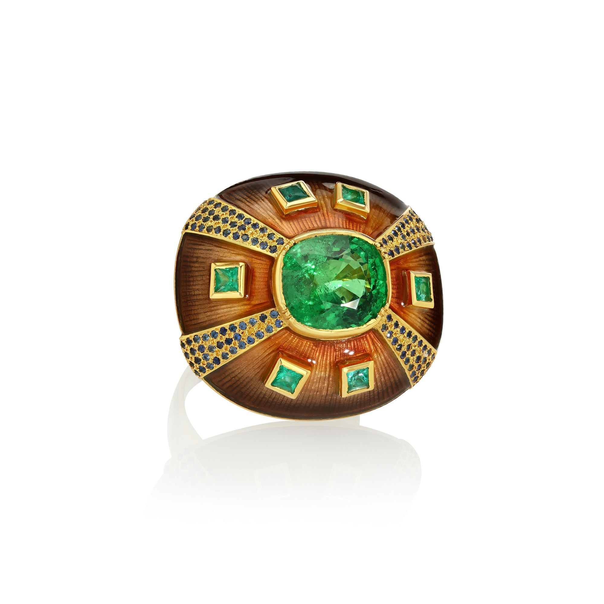 Decorative ring with green tsavorites and emeralds and blue sapphires with enameling and engraving on a white background.