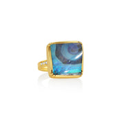 Front shot of gold ring with a boulder opal blue gemstone on a white background.