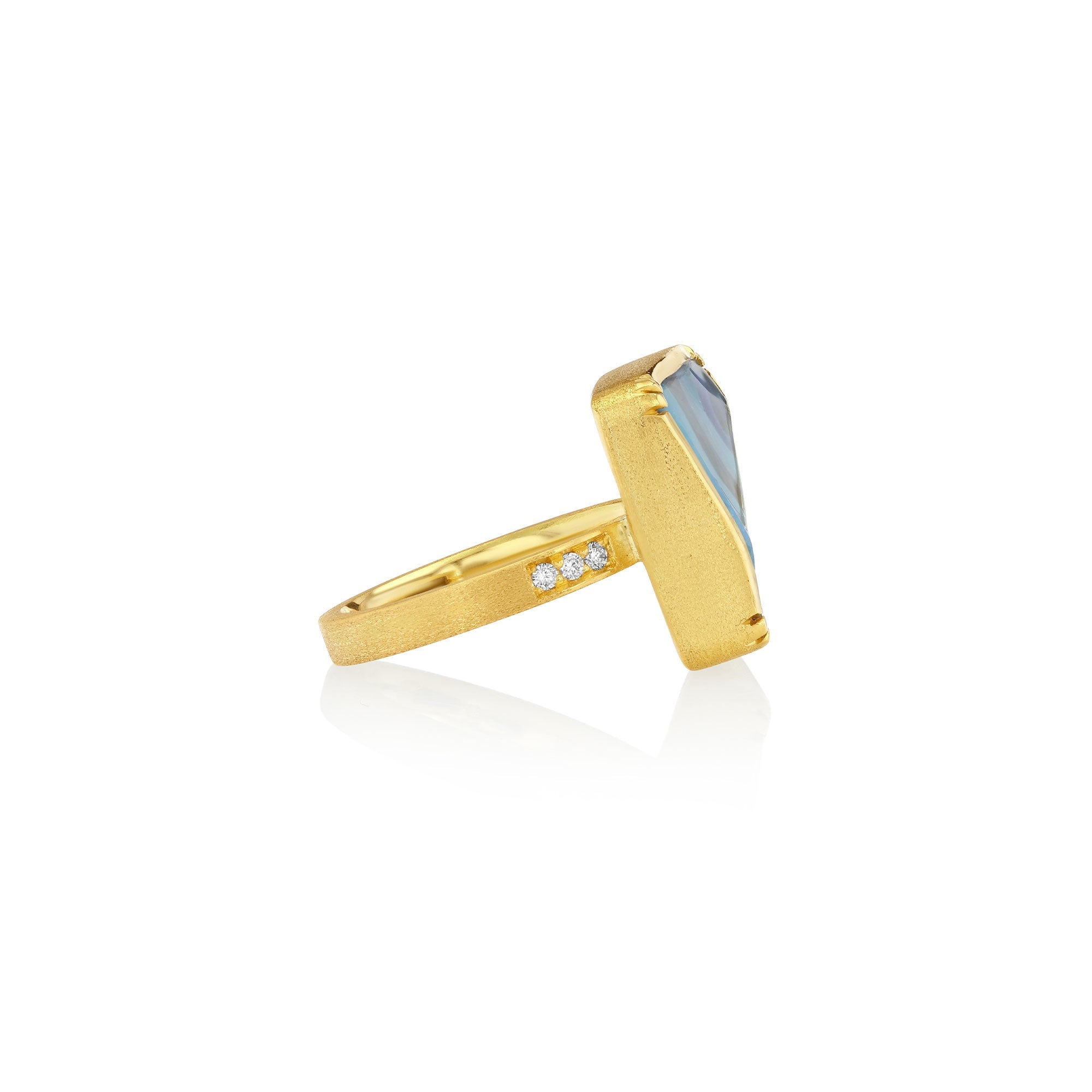 Side shot of gold ring with a boulder opal blue gemstone on a white background.