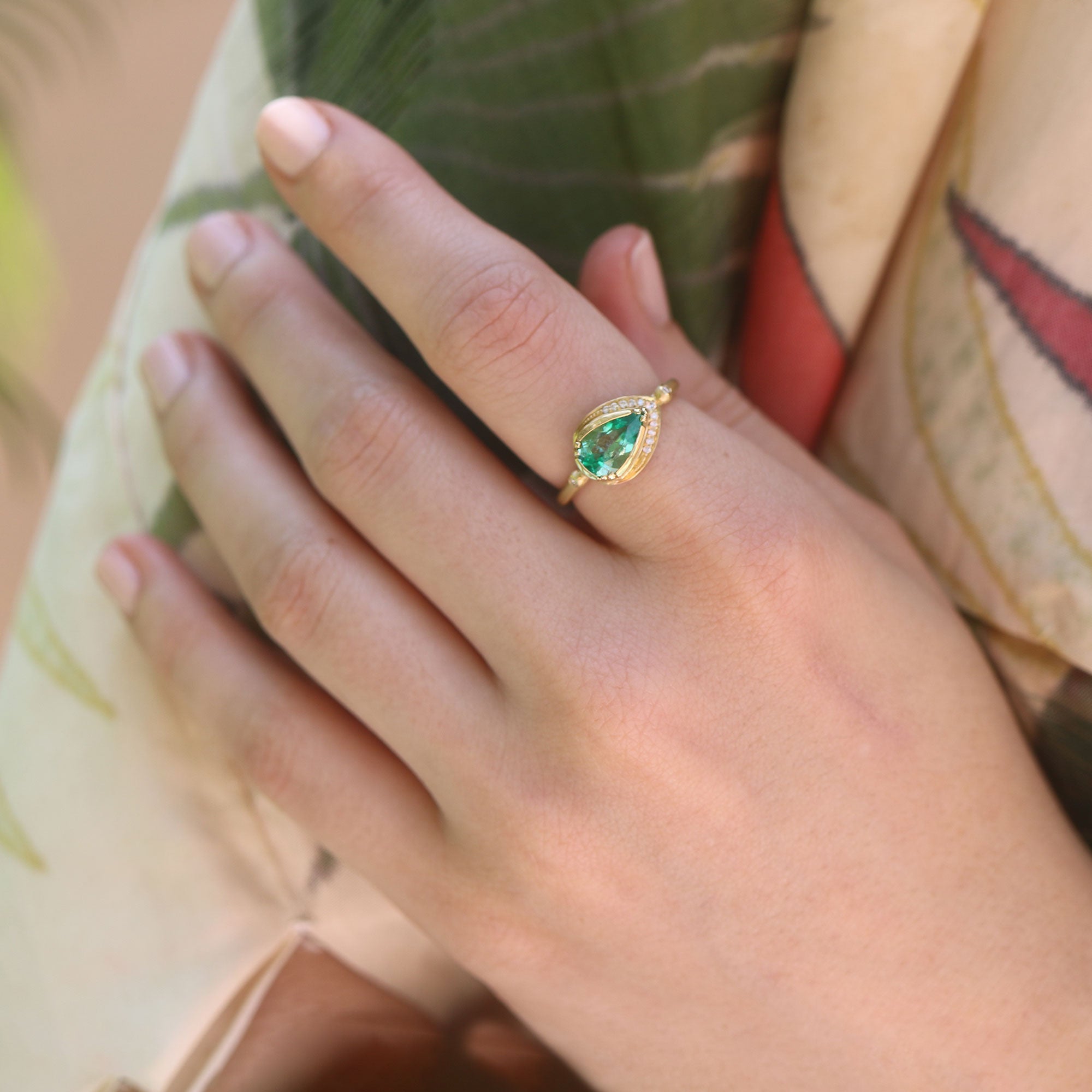 Model wearing one of a kind 18 gold Emerald ring with Diamond from fine jewelry designer Brooke Gregson handmade in London.