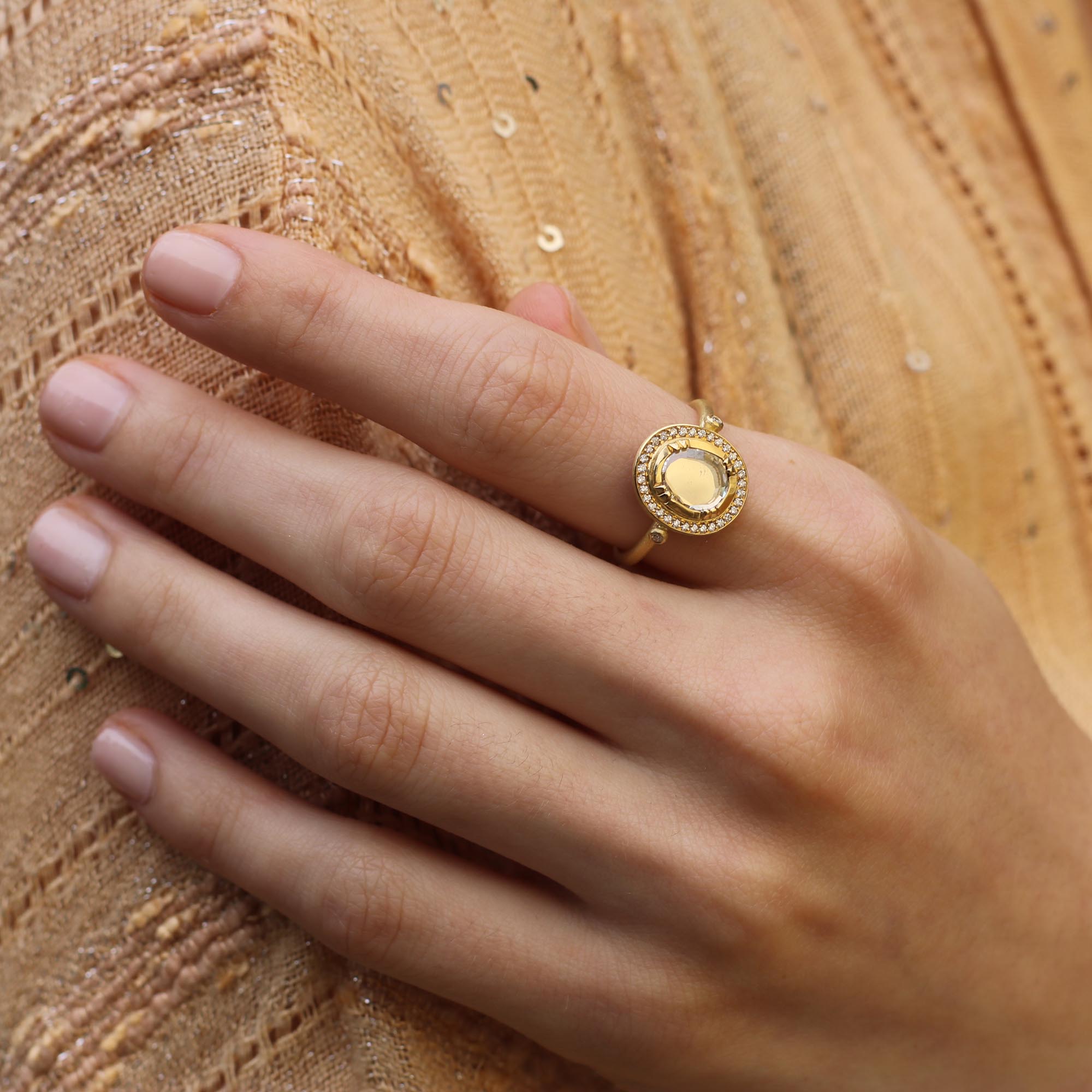 Model wearing one of a kind 18k gold ring with a central diamond surrounded by a halo of diamond pave from Los Angeles jewelry designer Brooke Gregson handmade in London