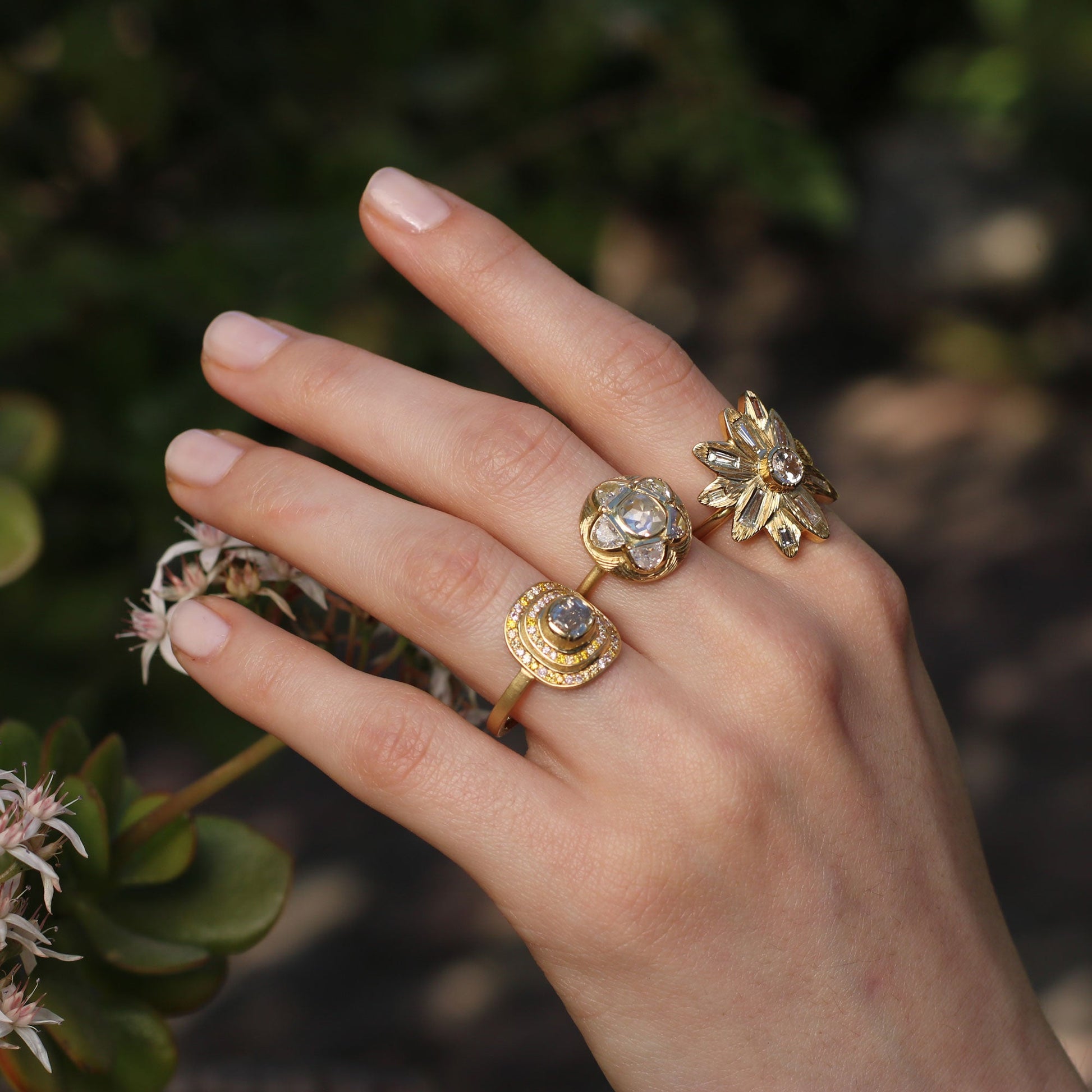 Model wearing multiple diamond ring, One of a kind 18k gold Diamond ring with tapered baguette diamond, hand engraved petals. Fine jewellery hand made in London from Los Angeles designer Brooke Gregson