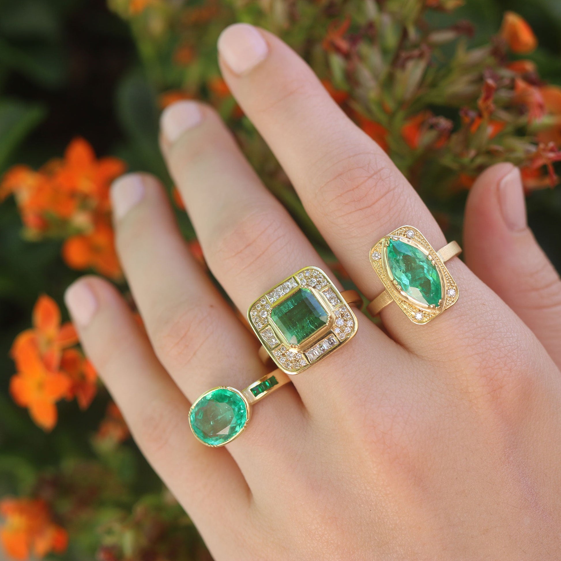Model wearing various Emerald rings with diamond accents from Los Angeles designer Brooke Gregson fine jewelry handmade in London.