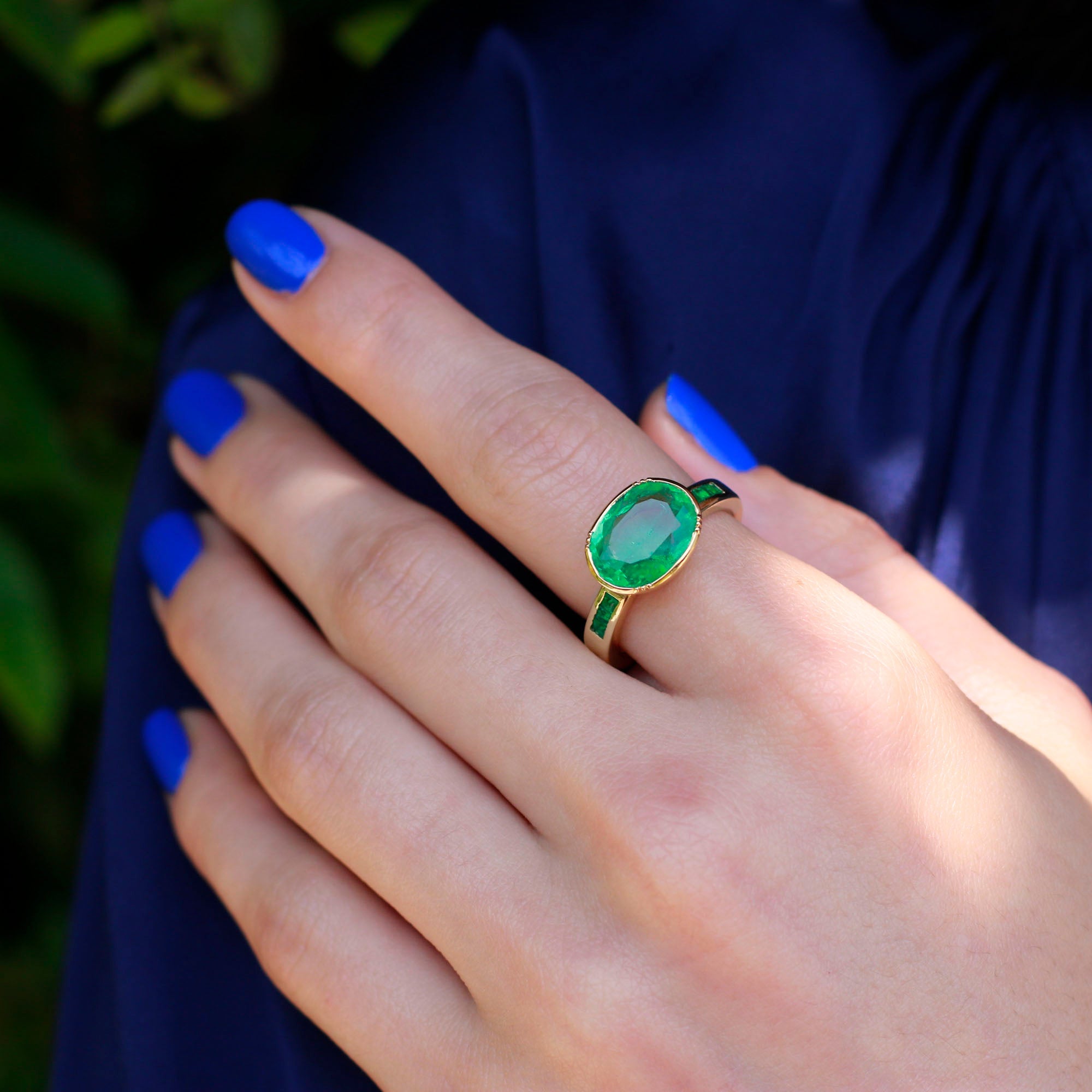 Model wearing one of a kind 18k gold ring with large emerald centre and emerald band detail from Los Angeles jewelry designer Brooke Gregson