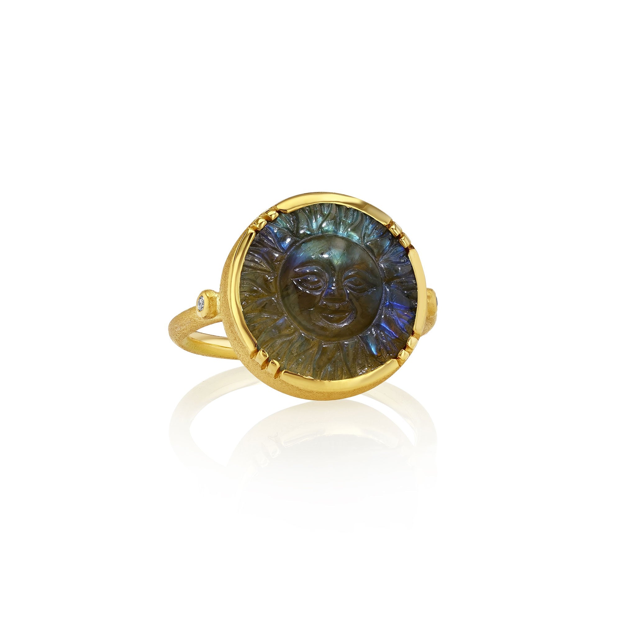 Gold ring with a carved labradorite face design on a white background