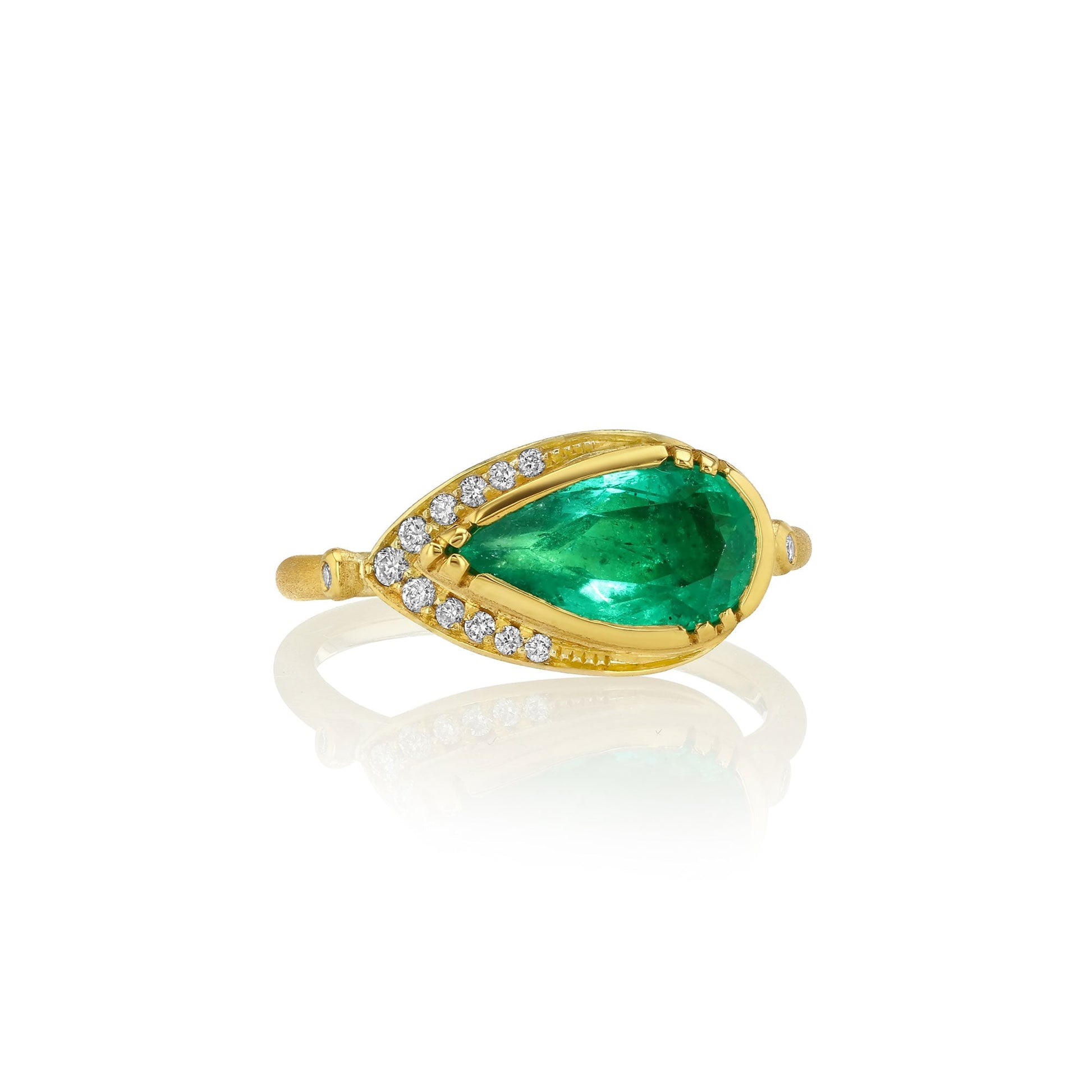 18k gold ring with a green emerald gremstone and small diamonds on a white background