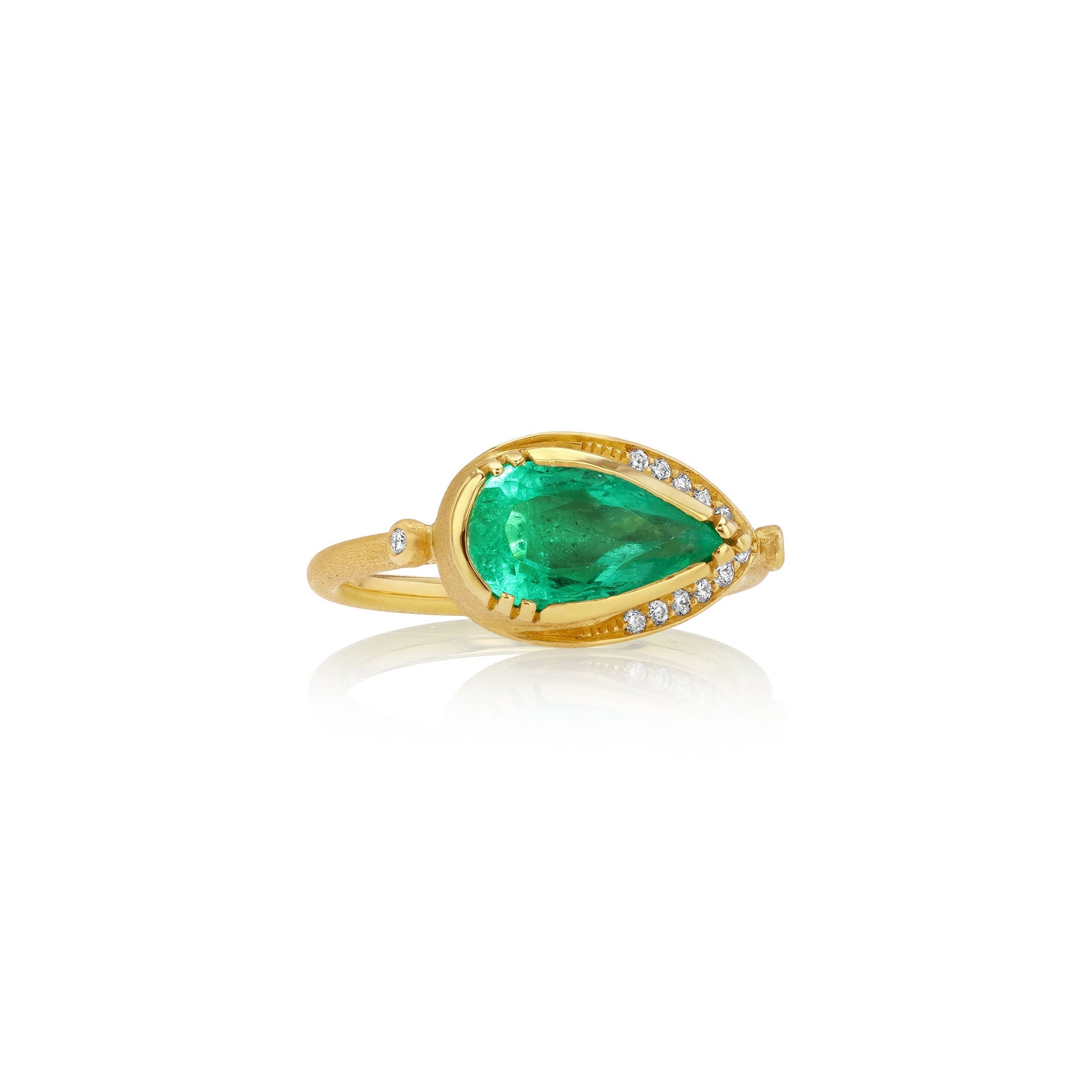 A gold ring featuring a large pear-cut green emerald center stone, accented by small clear pavé diamonds along the band, shown on a white background with a soft reflection.