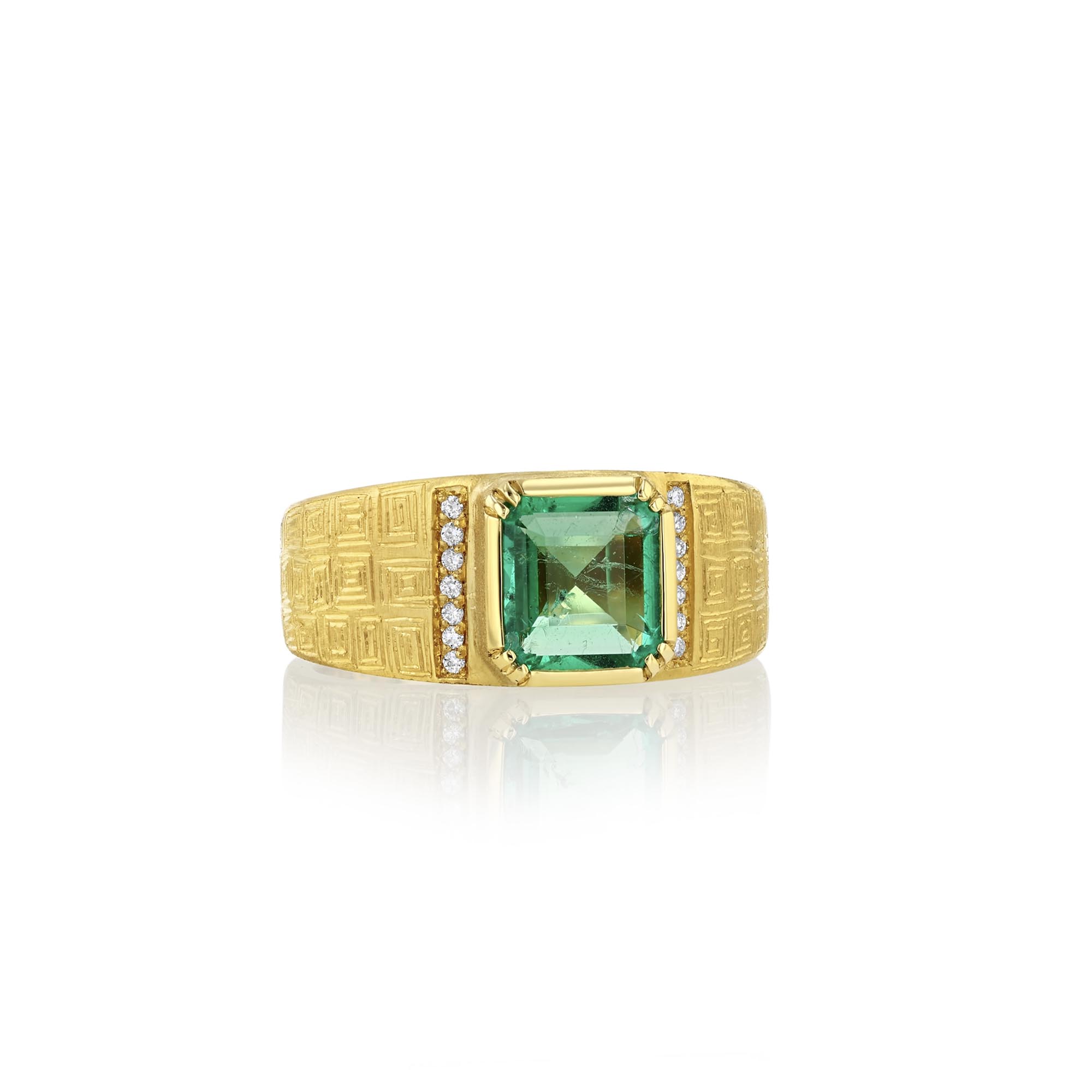Gold ring with a green emerald gemstone on a white background