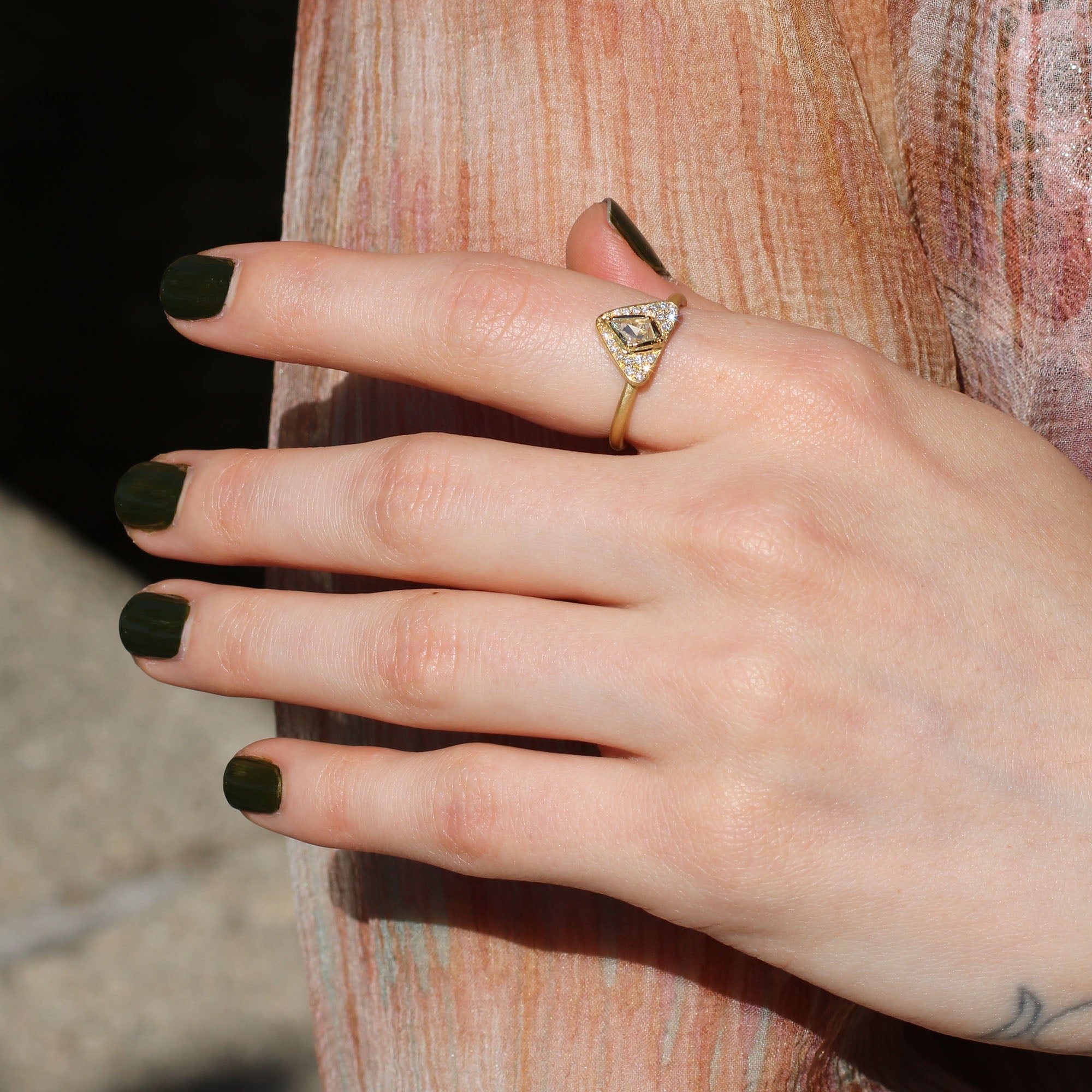 Hand wearing 18k gold ring with a triangular diamond from Los Angeles designer Brooke Gregson, fine jewelry handmade in London